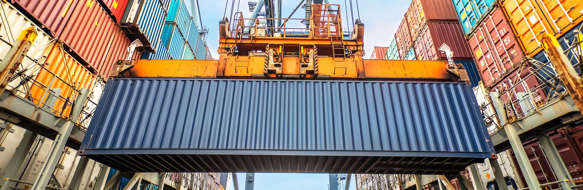 Shipping container being moved by crane